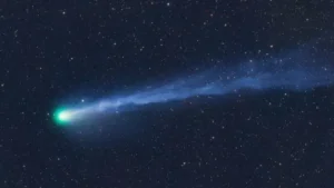 The Explosive Green Comet Racing Towards Earth and Andromeda Galaxy