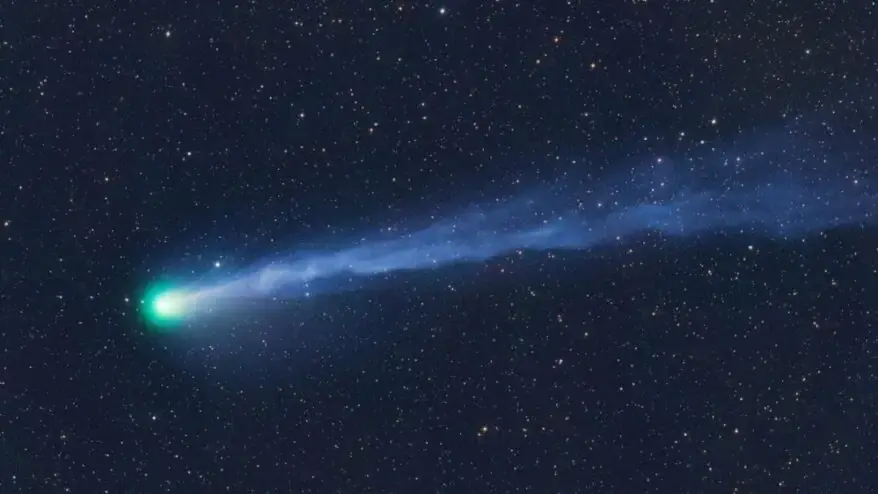 The Explosive Green Comet Racing Towards Earth and Andromeda Galaxy